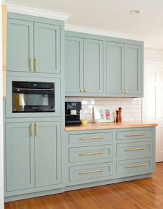 a kitchen with blue cabinets and wooden floors