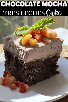 chocolate mocha tres leches cake on a plate with strawberries and mint leaves