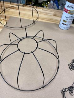 two wire baskets sitting on top of a table next to a bottle of paint and chain