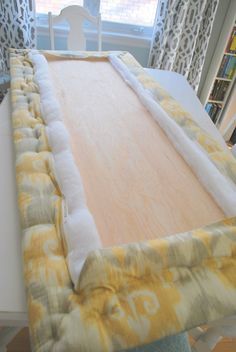 a bed with a yellow and white blanket on top of it