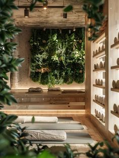 an indoor yoga room with green plants on the wall and white mats on the floor