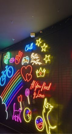 neon signs are displayed on the wall in this dark room