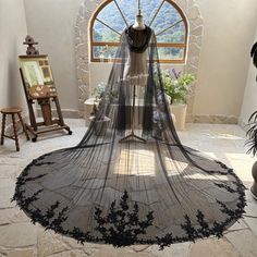 a black veil is hanging in front of a window with an arched window behind it