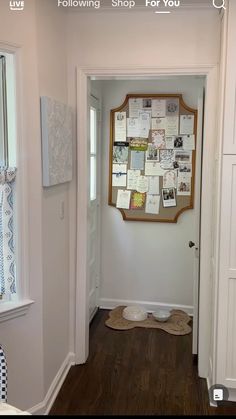 an open door leading to a room with pictures on the wall and papers all over it