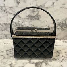 Description: This is beautiful 1996 Fall Collection vintage black patent leather Chanel vanity box purse featuring a diamond quilted pattern, top handle, two silver logo CC Chanel logo buttons on side, and a silver-plated rim on the top of the bag which reads ‘CHANEL PARIS’. The bag has a unique flap opening with a silver logo CC closure. As seen in Karl Lagerfeld’s 1996 Beverly Hills Hotel Campaign photographed on model Shalom Harlow. Designer: Chanel  Authenticity number: 4089174 Year: Fa Black Box Bag For Shopping, Vintage Pre-owned Formal Bags, Pre-owned Top Handle Bags For Formal Occasions, Designer Rectangular Box Bag For Evening, High-end Black Rectangular Box Bag, Designer Square Box Bag For Evening, Designer Evening Box Bag With Rectangular Case, Classic Rectangular Box Bag With Original Box, Designer Formal Rectangular Box Bag