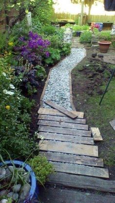 a wooden walkway in the middle of a garden