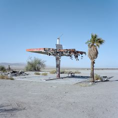 an old airplane sitting on top of a wooden pole in the middle of a desert