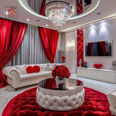 a living room with red curtains, white furniture and a chandelier hanging from the ceiling