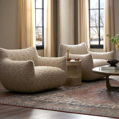 a living room with two chairs and a coffee table in front of the couches