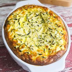 a casserole dish with spinach and cheese in it sitting on a table