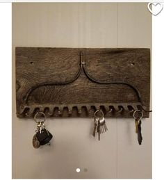 a wooden coat rack with keys hanging from it's hooks and two key holders