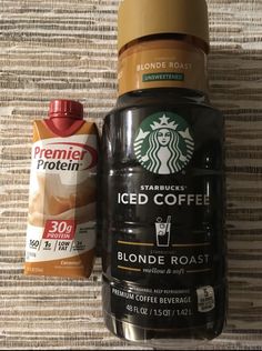 a cup of coffee next to a container of iced coffee and a bag of starbuck's iced coffee