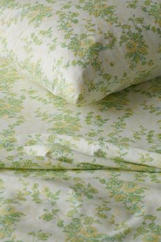 the sheets and pillow cases are covered with green flowers