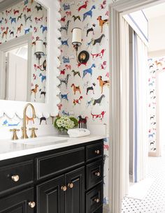 a bathroom with black cabinets and wallpaper decorated with dogs on it's walls