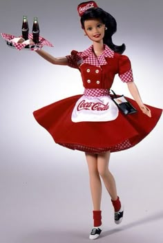 a woman in a coca - cola dress is holding two bottles and a cell phone