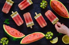 watermelon popsicles with limes and mint on a black surface, top view