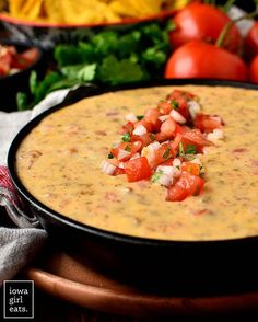 a bowl of dip with tomatoes, onions and cilantro