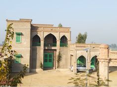 a car parked in front of a building with green shutters and arched doorways