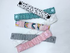 four different colored hair ties laying next to each other on a white surface with polka dots