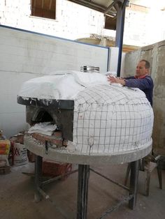 a man standing next to an oven in a building