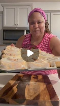 a woman holding a tray with food on it in front of a kitchen counter top