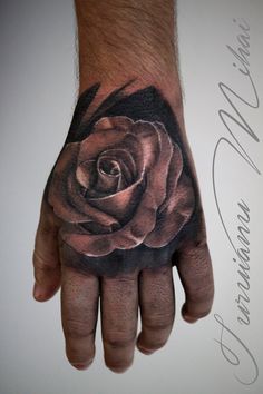 a hand with a rose tattoo on it