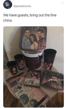 a table topped with cups and plates covered in movie posters next to a tin can