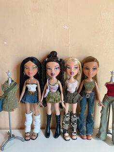 five dolls standing next to each other in front of a wall