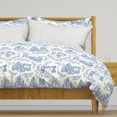 a bed with blue and white comforters on it