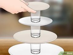 a three tiered cake stand with water in the middle and someone reaching for it