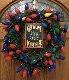 a christmas wreath with lights and a sign that says, got a little kind of here