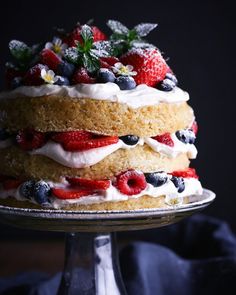 a layered cake with berries and whipped cream