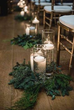 candles and greenery on the floor in front of chairs