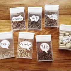 five clear containers filled with different types of beans and nuts, each labeled with an individual's name