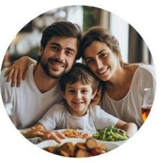 a man, woman and child sitting at a table with food in front of them