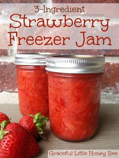 strawberry freezer jam in two jars with strawberries next to it