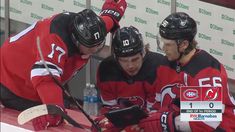 two hockey players are looking at a tablet