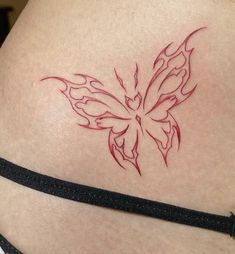 a butterfly tattoo on the back of a woman's stomach is shown in red ink