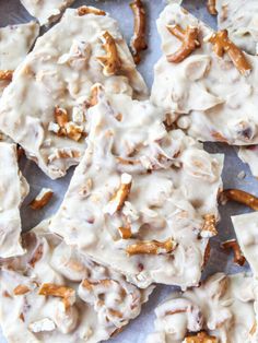 some kind of food that is covered in white icing and pecans on a sheet of paper