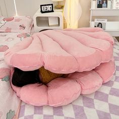 a person laying on top of a bed with a pink pillow in the shape of a flower