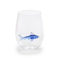 a clear glass with a blue fish in it's mouth on a white background