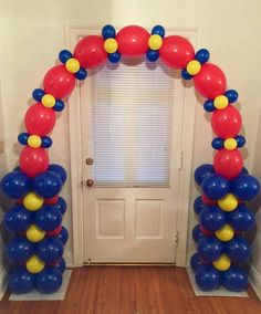 an arch made out of balloons in front of a door