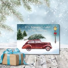 a christmas card with an old car carrying a tree