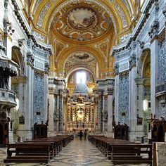 the inside of a church with pews and ornate decorations on the walls, along with marble flooring