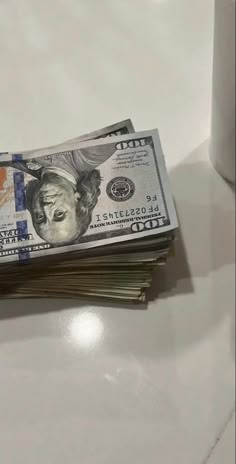 stacks of money sitting on top of each other next to a coffee cup and pen