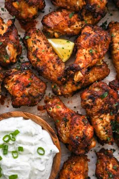 chicken wings with sour cream and chives on the side, ready to be eaten