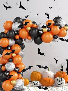 an arch made out of balloons with bats and pumpkins