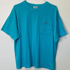 "Adult L Poly cotton blend 46\" chest 25\" length Awesome vintage cerulean blue 80s tee with a button pocket at the chest. Very soft and comfy, in great vintage condition with no noticeable flaws" Blue Crew Neck T-shirt With Pockets, Blue Vintage T-shirt With Relaxed Fit, Blue T-shirt With Pockets And Short Sleeves, Vintage Washed Blue Crew Neck Top, Vintage Crew Neck Top With Pockets, Blue Vintage Style T-shirt With Relaxed Fit, Vintage Washed Blue Tops With Pockets, Light Blue Tops With Pockets For Everyday, Casual Turquoise Crew Neck T-shirt