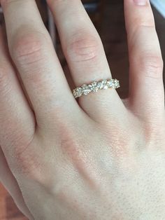 a woman's hand with a wedding ring on her left and an engagement band on her right