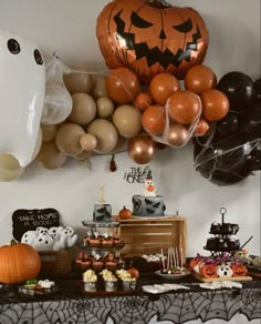 a table topped with lots of balloons and halloween themed food on it's side